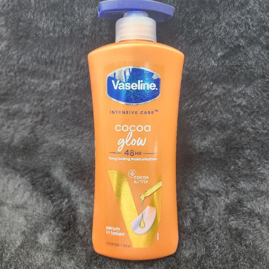 Vaseline Cocoa Glow Body Lotion 48HR Cocoa Butter Moisturizer in plastic bottle with orange, blue, gold and white packaging for men and women